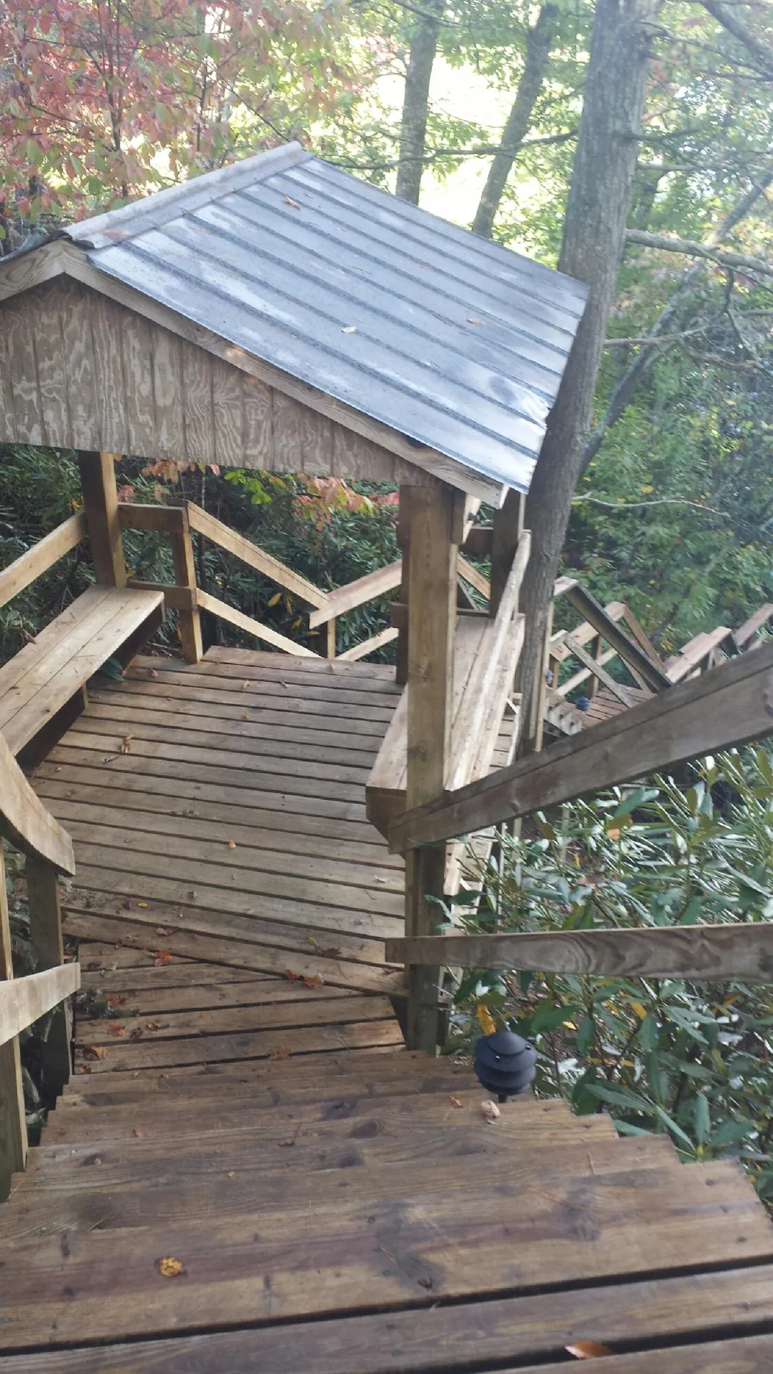 Metal roofed shelter over wooden steps on a wooded walkway — Skylight Repair & Installation work by our crew in Danbury